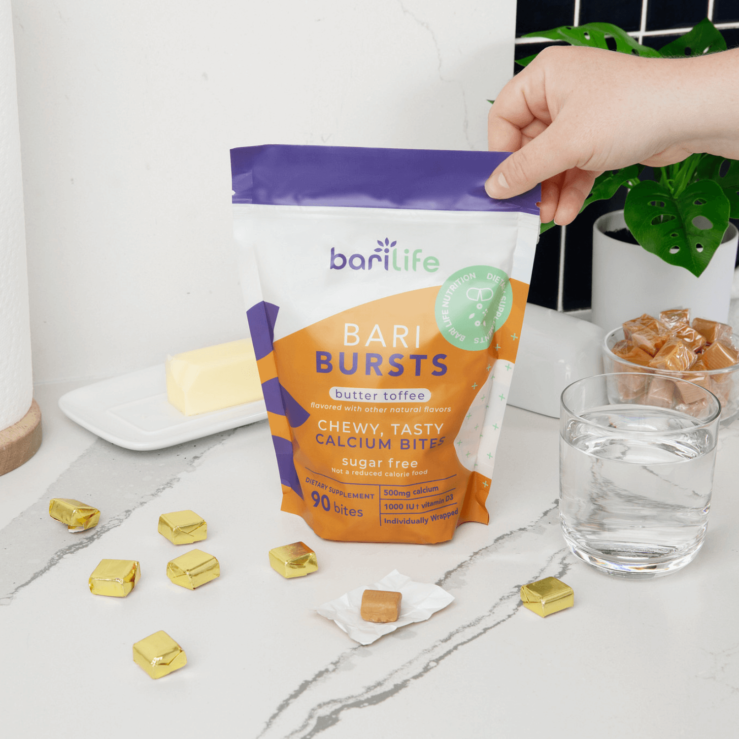 BariBurst butter toffee calcium chews in a colorful package on a kitchen counter with water and treats.